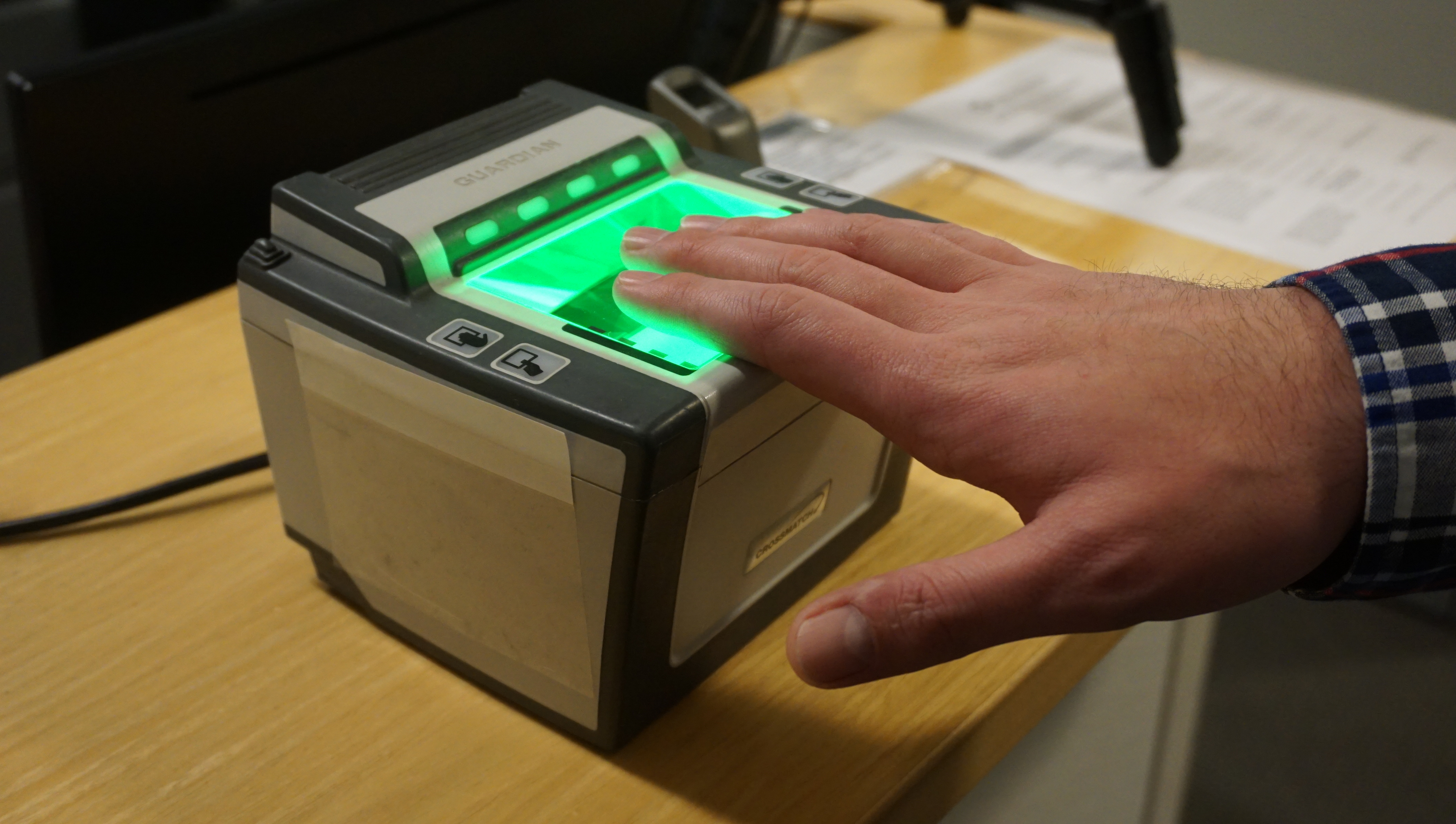 Hand on top of finger print machine for security clearance. 