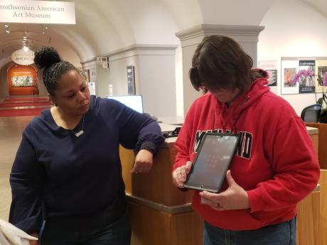 A Smithsonian employee and visitor using the VRI service via a tablet