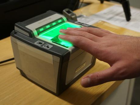 Hand being fingerprinted on machine. 